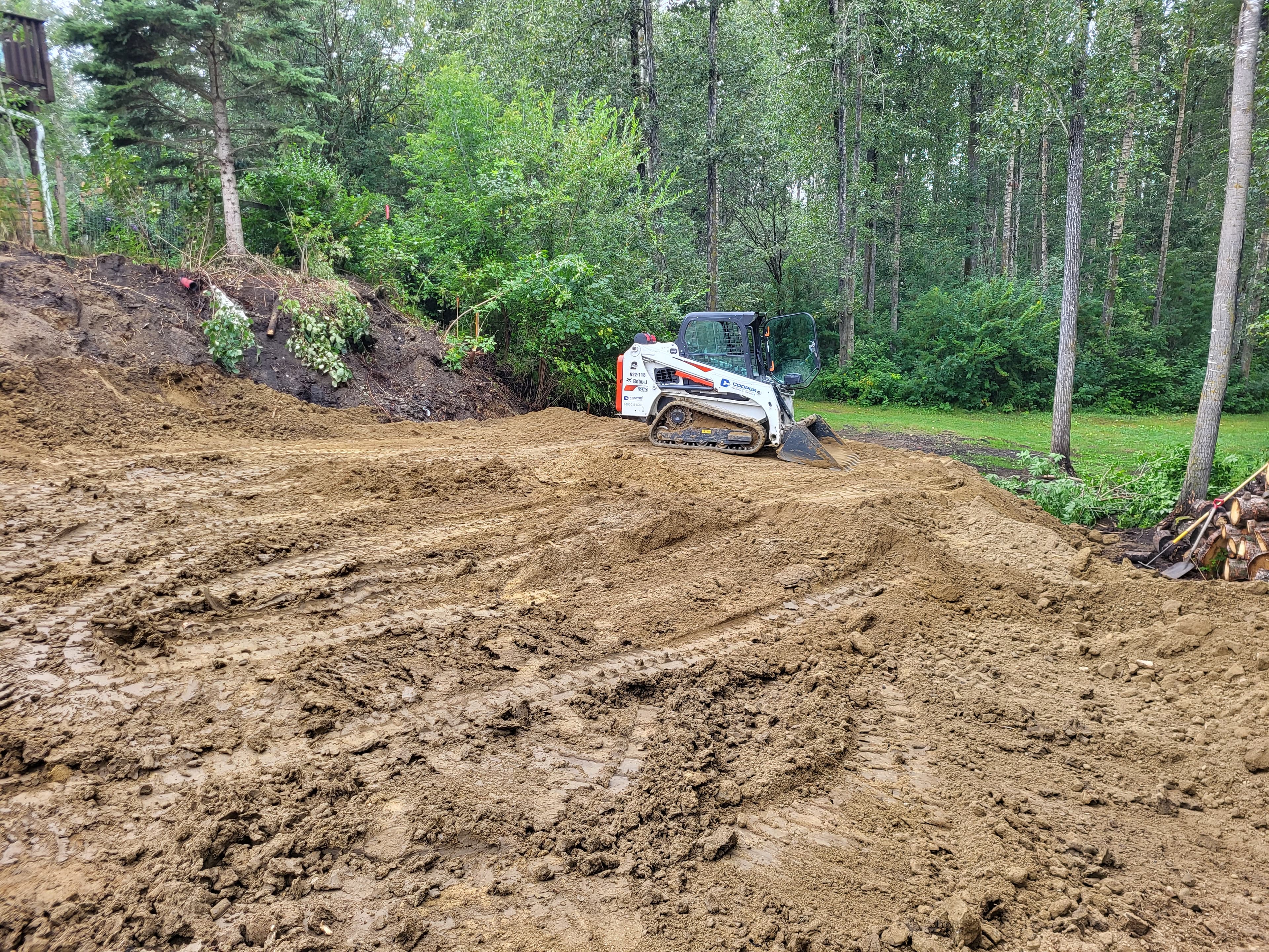 Track loader grading a wooded lot