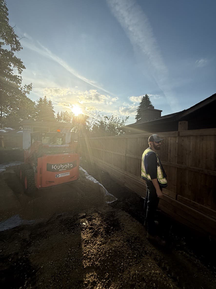 Worker with Kubota loader at sunset